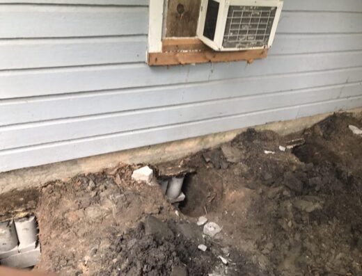 Excavated access pit exposing a home's foundation and exterior wall during a J R Foundation Repair job in South Houston