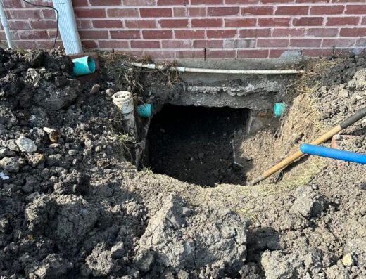 Jack it Up Foundation Specialists excavation pit exposing a brick home's foundation for pier installation