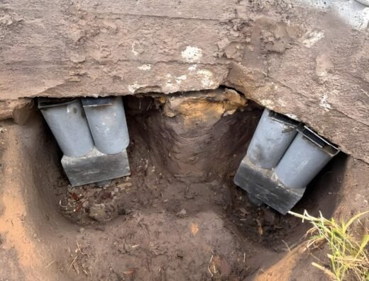 Exposed concrete pilings installed beneath a Houston home's foundation by Valued Foundation Repair