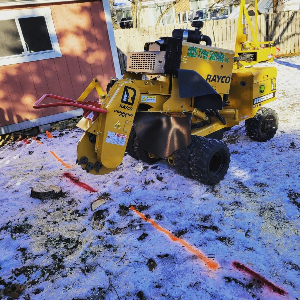 DOS Tree Service branded yellow stump grinder on a residential job site