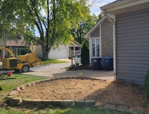 DOS Tree Service stump grinder equipment arriving at a residential driveway